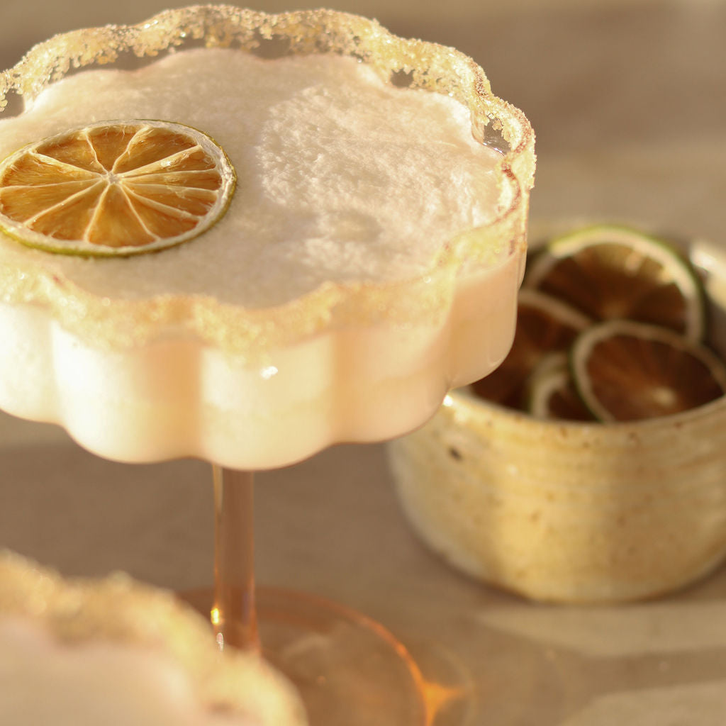 A creamy coconut margarita dressed to impress with dried lime and lime rim blend rim salts