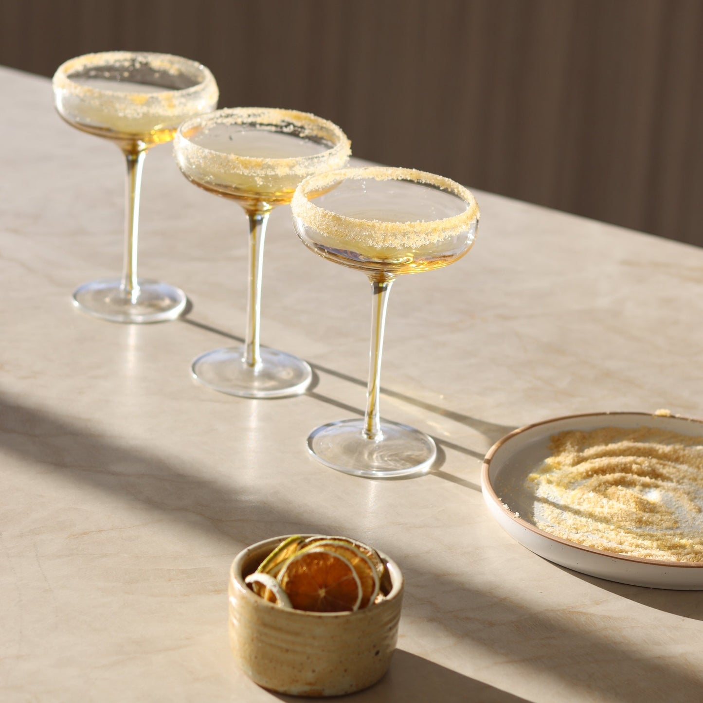 3 empty cocktail glasses that have just been garnished with the cocktail rim blend